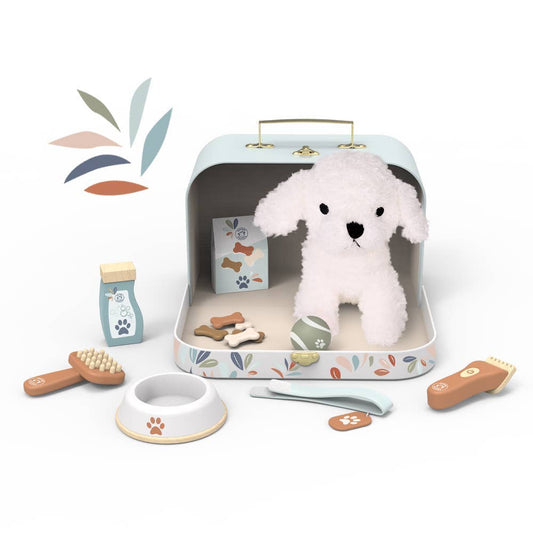 A children's pretend pet-care playset arranged on a white background. The set includes a small open metal case with a plush white dog inside, plus accessories such as a bowl, brush, treats, bandage, and a clipper, all styled as part of a pet-care theme.