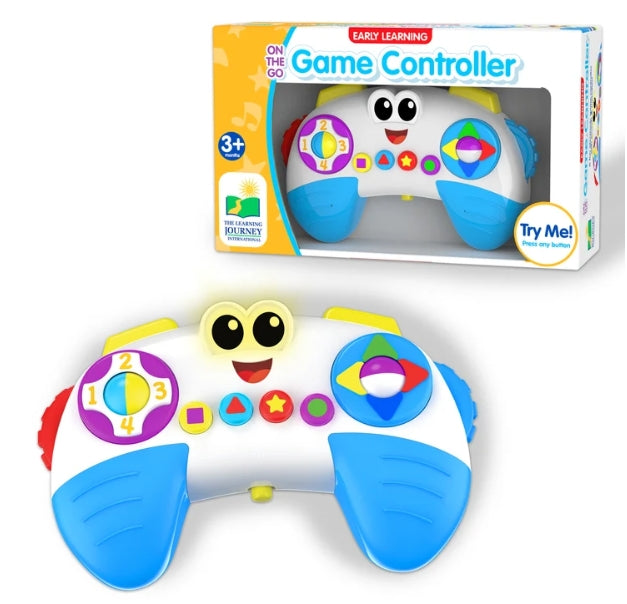 A colorful baby toy game controller shown in front of its retail packaging box. The toy is white with bright blue grips and a smiling cartoon face, featuring purple, yellow, green, and red directional buttons.