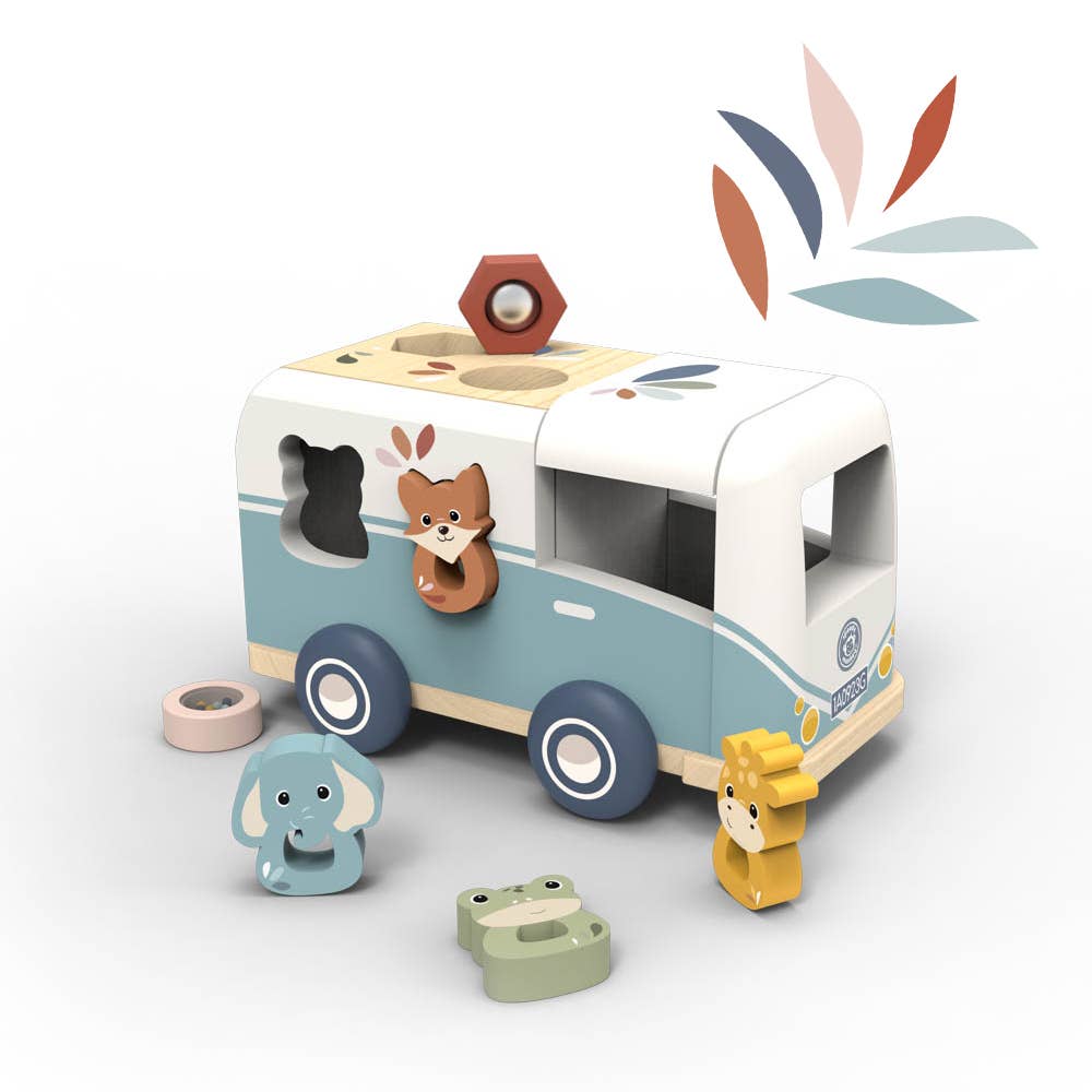 A wooden animal-themed toy set featuring a light blue and cream van with animal-shaped cutouts and movable pieces, including a fox, elephant, frog, lion, and a hex nut, shown on a clean white background with a leaf motif in the upper right.