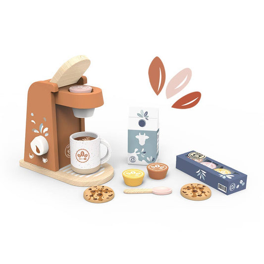 A children's wooden pretend-play coffee set on a white background, including a tan coffee machine, white mug with coffee, milk carton, coffee capsules in a blue box, yellow and brown cups, cookies, a spoon, and floating leaf graphics.